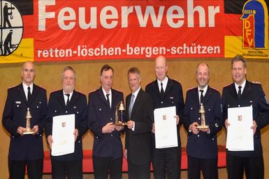 Landrat Oliver Stolz überreicht die Silberne Glocke an die Wehrführungen der Geburtstags-Wehren: Kay Sierk (von links, Wehrführer FF Westerhorn), Lothar Sauer (stellv. Wehrführer FF Westerhorn), Dieter Dräger (Wehrführer FF Brande-Hörnerkirchen/Osterhorn), Jens Grafe (stellv. Wehrführer FF Brande Hörnerkirchen/Osterhorn), Volker Kunrath (Wehrführer FF Bokel) und Thorsten Huckfeldt (stellv. Wehrführer FF Bokel)