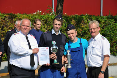 Quickborns stellvertretender Wehrführer Daniel Dähn(links) und Kreisjugendfeuerwehrwart Ernst-Niko Koberg übergaben der siegreichen JF Klein-Nordende den Pokal und den Wanderpokal.