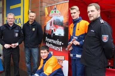 Bild 1: Kreisjugendfeuerwehrwart Ernst-Niko Koberg, der EDEKA- Filialleiter Ulf Harms (links) und Patrick Grosse der Quickborner Jugendwart (rechts) mit zwei Jugendlichen.